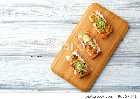 Delicious vegetable bruschetta slices on wooden board Delicious vegetable bruschetta slices on wooden board 96357471