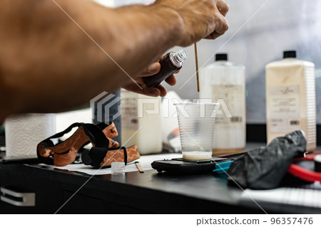Close up of man car service worker making glue for applying car protective film 96357476