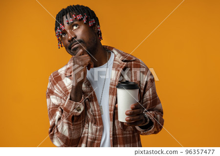 Young african man holding cup of take away coffee over yellow background 96357477