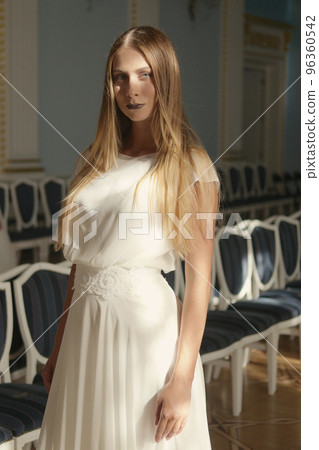 Beautiful young woman in ivory silk dress Beautiful young woman in ivory silk dress 96360542