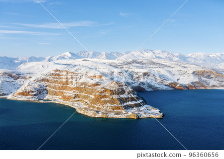 Amazing winter landscape of Charvak reservoir with blue water in Uzbekistan on a winter day. Tourist card of the country 96360656