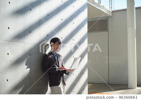 Man operating a computer while standing Man operating a computer while standing 96360661