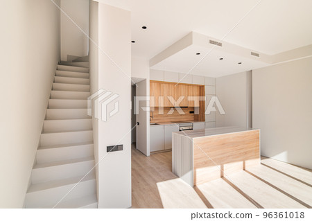 Empty interior of refurbished duplex with stairs and modern kitchen with island and wooden furniture 96361018