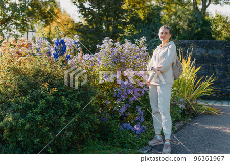 Beautiful elegant woman standing in autumn park with yellow leaves outdoor. Beauty Romantic Girl Outdoors enjoy autumn yellow leaves. Portrait of joyful woman in park during fall. Happy ng nature. Sun 96361967