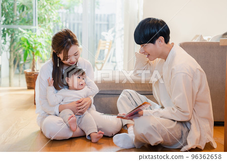 Parents reading a picture book to their baby 96362658