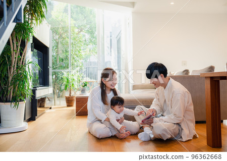 Parents reading a picture book to their baby 96362668