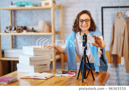 Female warehouse worker, seller, dropshipping small business owner recording new content for vlog. 96363550