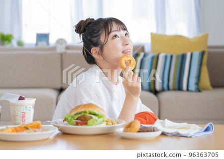 作弊日一個年輕女子手裡拿著一個甜甜圈微笑 96363705
