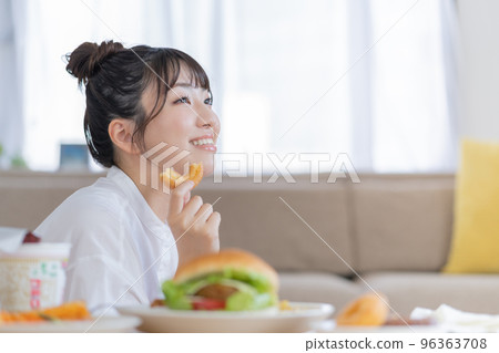 作弊日一個年輕女子手裡拿著一個甜甜圈微笑 作弊日一個年輕女子手裡拿著一個甜甜圈微笑 96363708