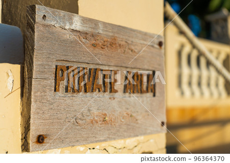 A sign warning about entering a private area, hanging on the fence of the property A sign warning about entering a private area, hanging on the fence of the property 96364370