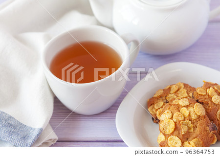 Cup of tea with cookies over lilac wooden background Cup of tea with cookies over lilac wooden background 96364753