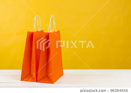 Arrangement of shopping bags on bright yellow background 96364856