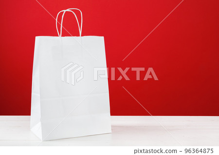 Paper shopping bags with copy space on red background Paper shopping bags with copy space on red background 96364875