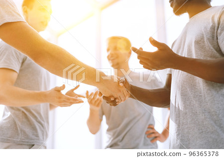 close up. two comrades shaking hands, standing in a circle of friends 96365378