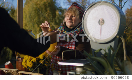 Elderly saleswoman stands at the stall Elderly saleswoman stands at the stall 96366038