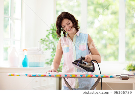 Woman ironing clothes. Home chores. 96366789