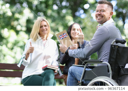 Happy disabled man in wheelchair is learning English with his friends. Happy disabled man in wheelchair is learning English with his friends. 96367114