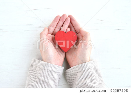 Woman's hand holding a heart object 96367398