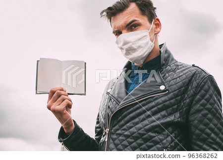 close up. a man in a protective mask showing his passport. 96368262