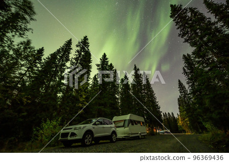 Aurora shining over Camping Caravan in Swedish forest Tannforsen Waterfall Northern Lights color sky Sweden, Scandinavia 96369436