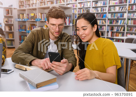 University students are studying in a library together as teamwork for preparation University students are studying in a library together as teamwork for preparation 96370891
