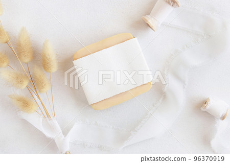 Soap bar with blank label near silk ribbons and dried hare's tail grass top view, mockup Soap bar with blank label near silk ribbons and dried hare's tail grass top view, mockup 96370919