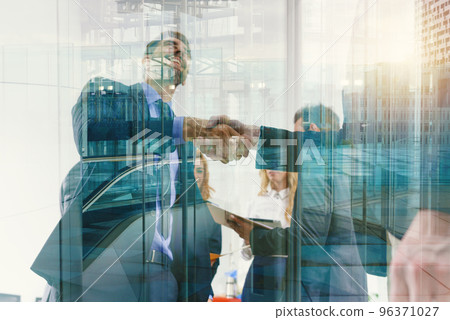 Handshaking business person in office as teamwork and partnership Handshaking business person in office as teamwork and partnership 96371027