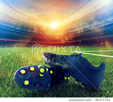 Soccer shoes on playground of a big stadium 96371752