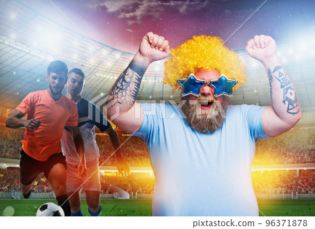 Soccer fan exults watching a football match at the stadium Soccer fan exults watching a football match at the stadium 96371878