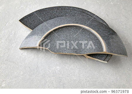 Two halves of a cracked ceramic plate on a gray concrete table Two halves of a cracked ceramic plate on a gray concrete table 96371978