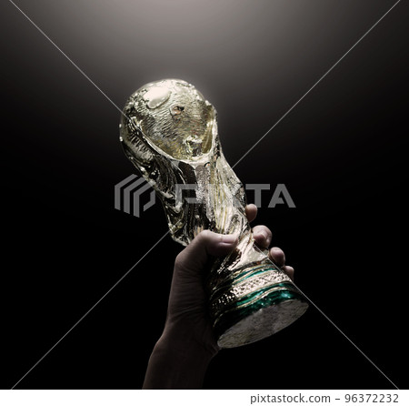 Bangkok Thailand. July 15 2018. Mock Up of the FIFA World Cup Trophy in hand and Black Background. Man holding a trophy of the FIFA World Cup in hand. Fifa 2022 winning trophy is raised up in the air. 96372232