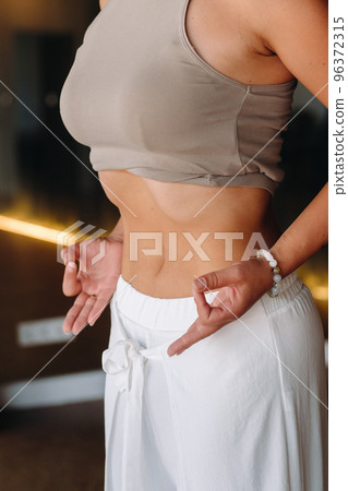 a woman does breathing exercises in the fitness room. Home sports training for the muscles of the press a woman does breathing exercises in the fitness room. Home sports training for the muscles of the press 96372315