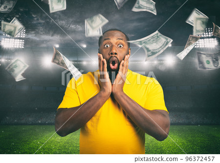 Astonished man for winning a sport bet. rain of money inside a soccer stadium 96372457