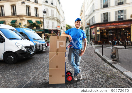 Man with blue uniform in front of the shops for delivery and pickup of the goods 96372670