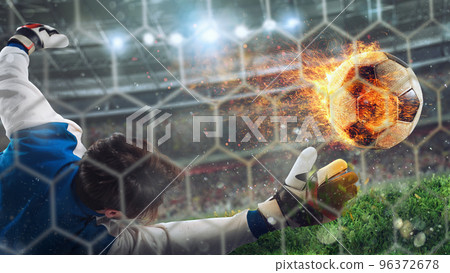 Goalkeeper catches a fast fiery soccer ball Goalkeeper catches a fast fiery soccer ball 96372678