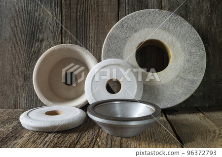 Industrial grinding and polishing wheels on a wooden table 96372793