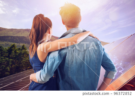 Family uses renewable energy system with solar panel 96372852