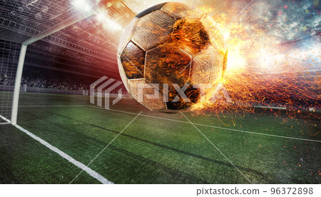 Close up of a fiery soccer ball kicked with power at the stadium scoring a goal Close up of a fiery soccer ball kicked with power at the stadium scoring a goal 96372898