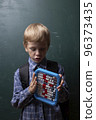 Child tries to solve mathematical problem with abacus. 96373435