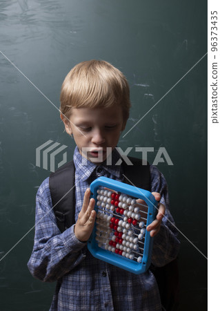 Child tries to solve mathematical problem with abacus. 96373435