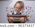optimistic Little beautiful smiling girl holding books 96373437