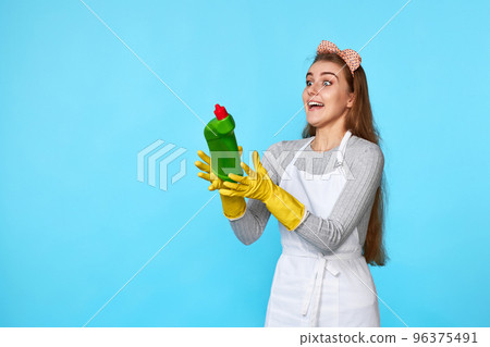 woman in rubber gloves catches flying bottle of detergent woman in rubber gloves catches flying bottle of detergent 96375491