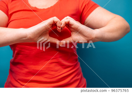 Woman making heart shaped hands, heart health insurance, social responsibility, gratitude, donation, happy charity volunteer, world heart day, recognition concept, world mental health day 96375765