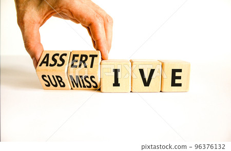 Submissive or assertive symbol. Concept words Submissive and assertive on wooden cubes. Businessman hand. Beautiful white background. Business, psychological submissive assertive concept. Copy space. 96376132