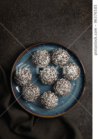 Coconut chocolate balls on plate. Top view. 96376585
