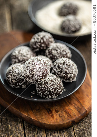 Coconut chocolate balls on plate. 96376591