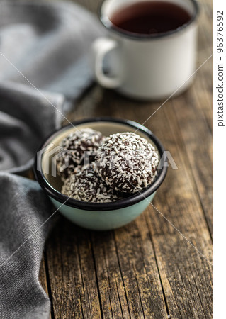 Coconut chocolate balls in bowl on wooden table. Coconut chocolate balls in bowl on wooden table. 96376592