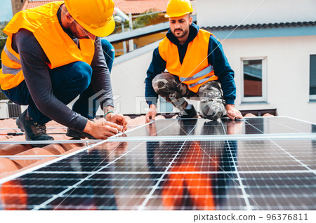 Workers assemble energy system with solar panel for electricity Workers assemble energy system with solar panel for electricity 96376811