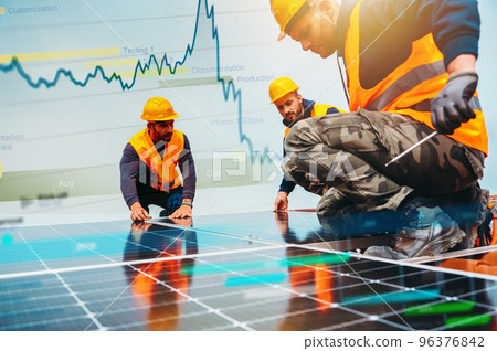 Workers assemble energy system with solar panel for electricity 96376842