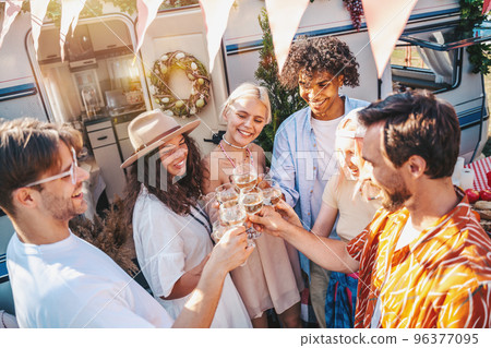 Friends have a picnic and toast with wine 96377095